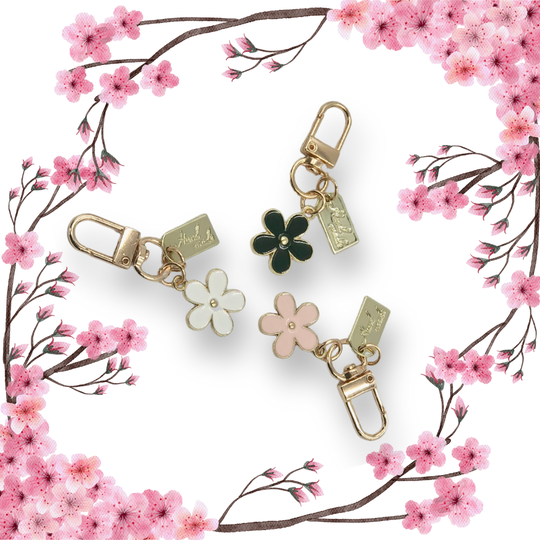 Blossom shaped handbag charms with cherry blossom branches and white background