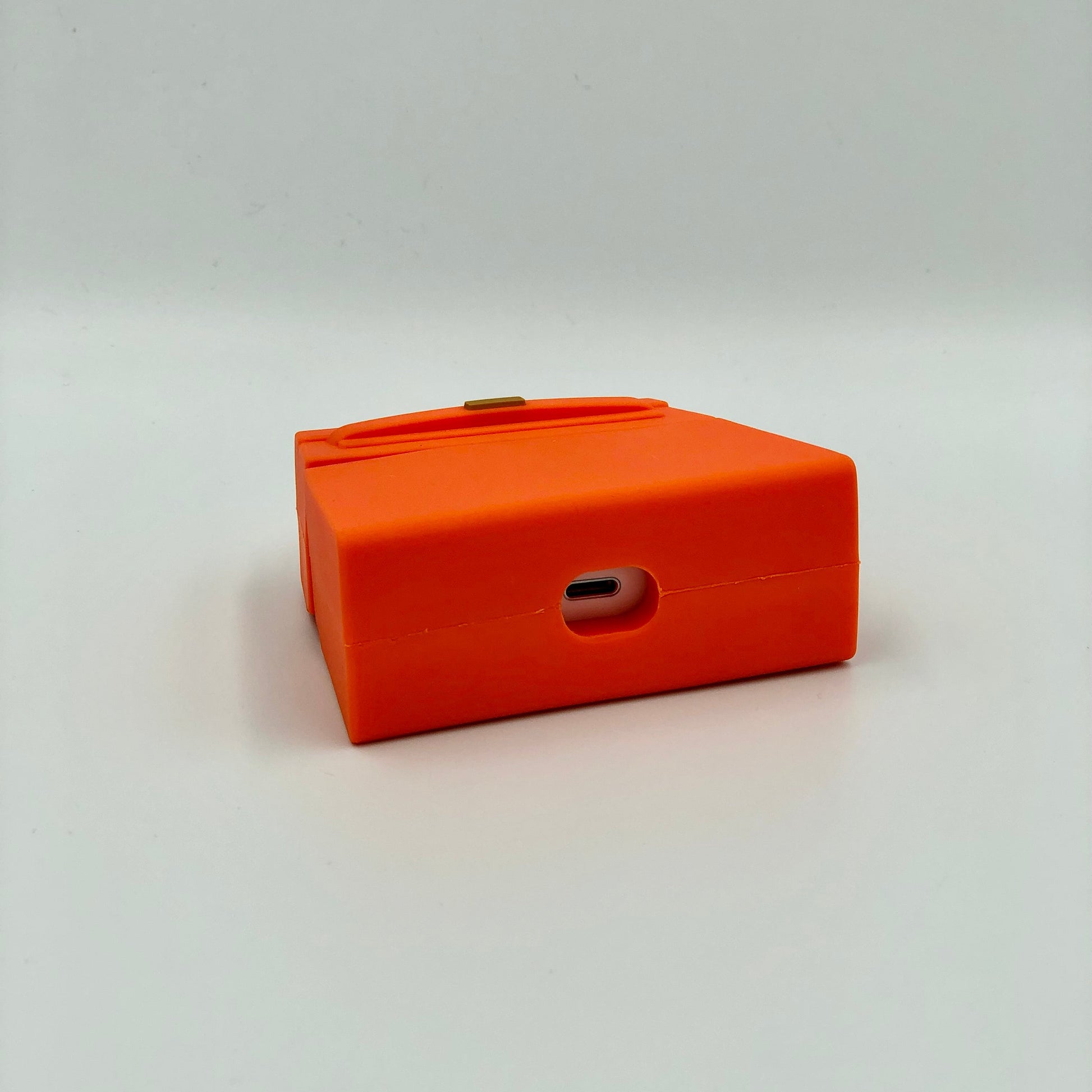 Orange Silicone Handbag Airpod Case - Bottom view. Apple AirPods and Apple Airpod case are for reference only and are not included.