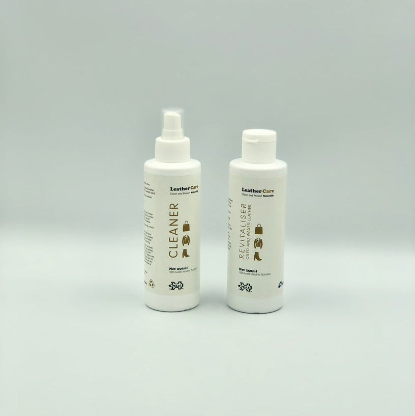 Two bottles of leather care products on a gray background