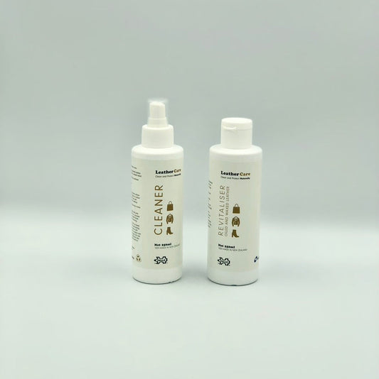 Two bottles of leather care products on a gray background