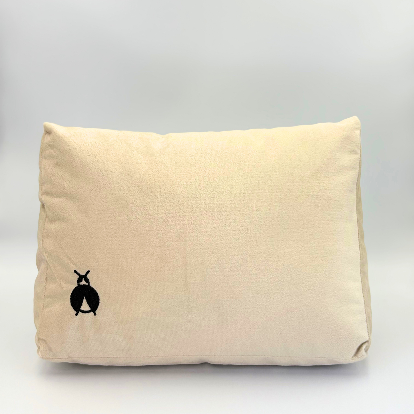 Front of a Beige Handbag Shaper with a black bug logo on a grey background