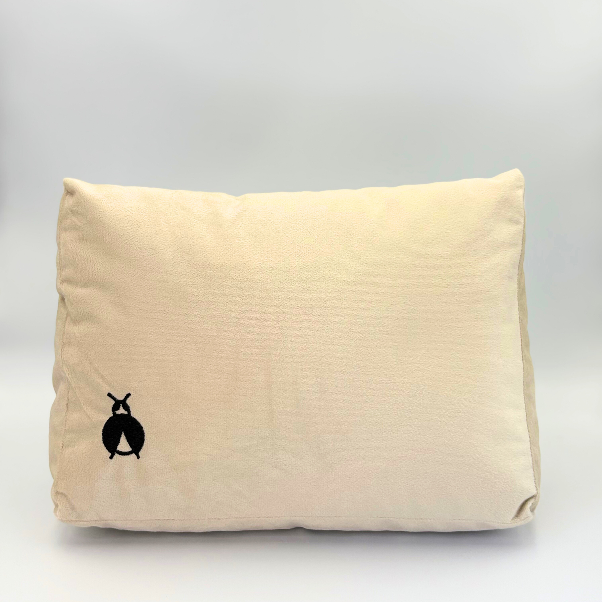 Front of a Beige Handbag Shaper with a black bug logo on a grey background