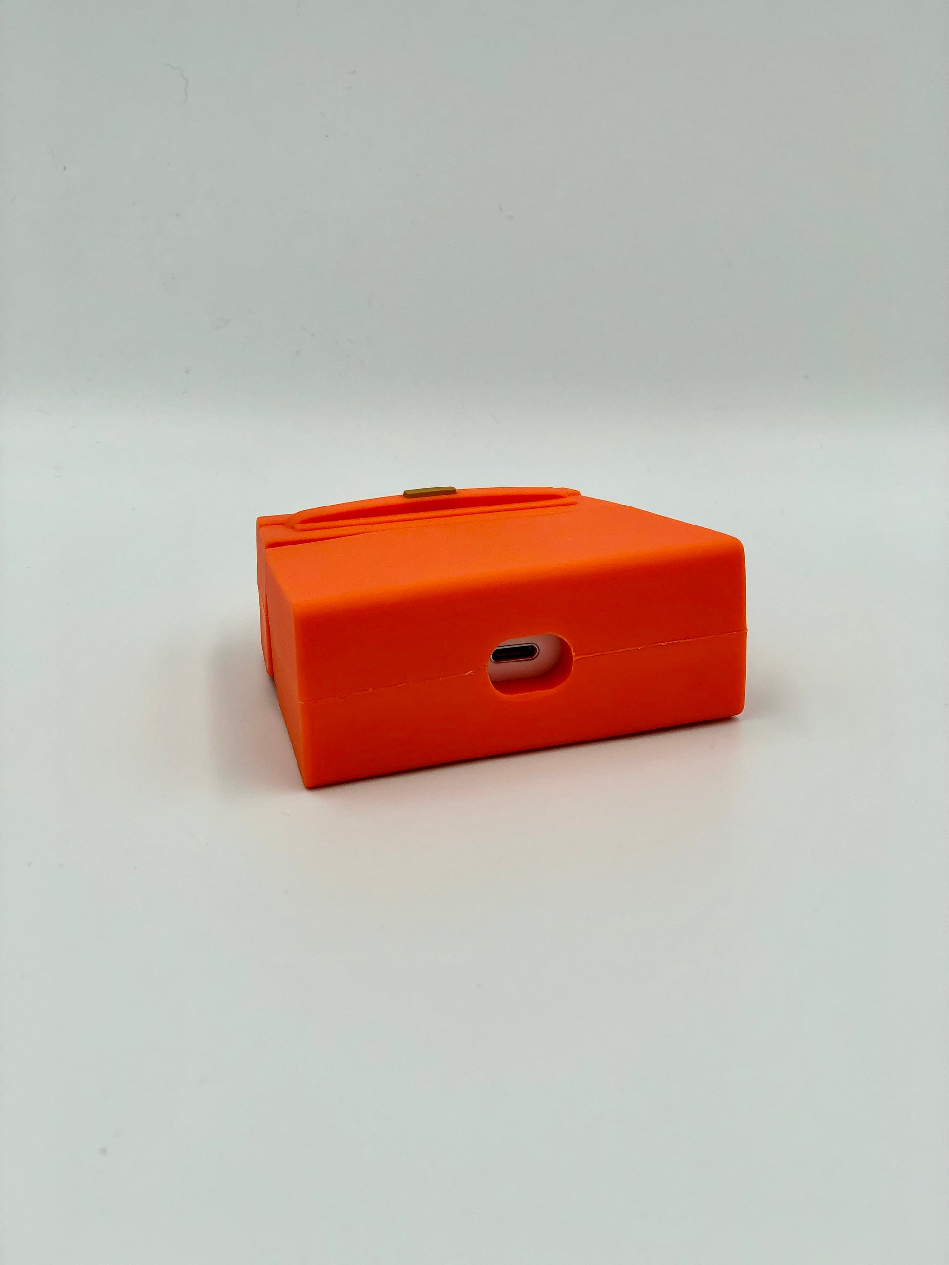 Orange Silicone Handbag Airpod Case - Bottom view. Apple AirPods and Apple Airpod case are for reference only and are not included.