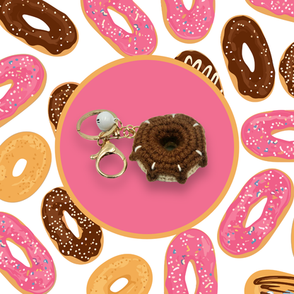 Brown donut-shaped crochet handbag charm on a pink background with donut pattern