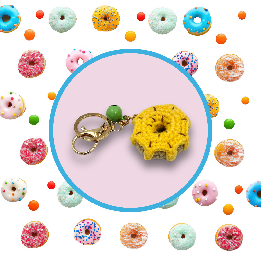 Yellow donut-shaped crochet handbag charm on a lilac background with donut pattern