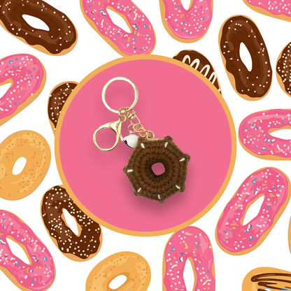 Brown donut-shaped crochet handbag charm on a pink background with donut pattern